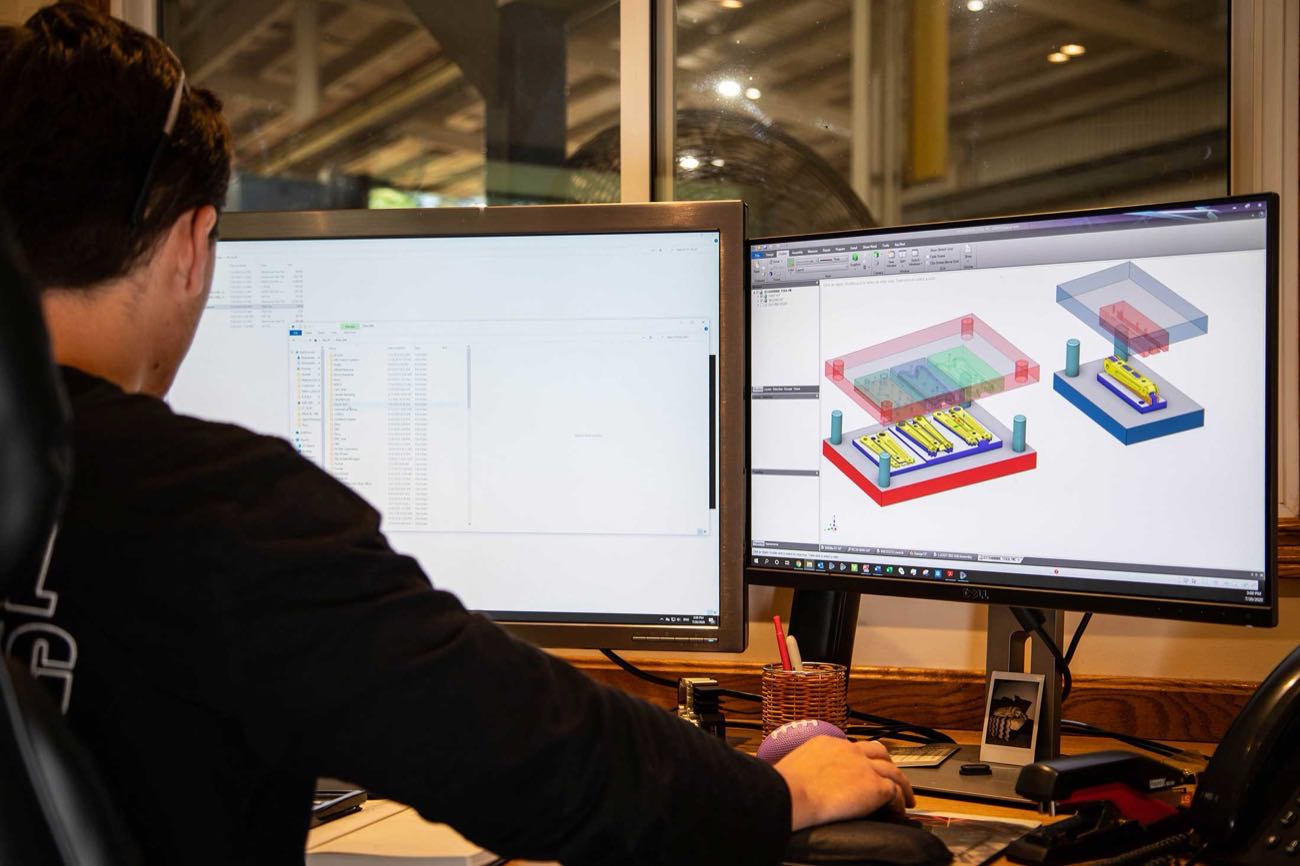 A Prototier-1 quality assurance team member reviewing inspection results against the part drawing
